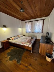 a bedroom with a large bed and a wooden ceiling at Кондеви къщи in Kovačevica