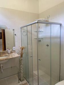 um chuveiro com uma porta de vidro na casa de banho em Casa da Cristina em Trancoso