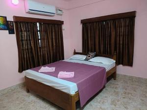 1 dormitorio con 1 cama con manta morada en Sea Edge Homestay, en Port Blair