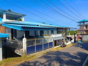 a house with a blue roof on a street at Sea Edge Homestay in Port Blair