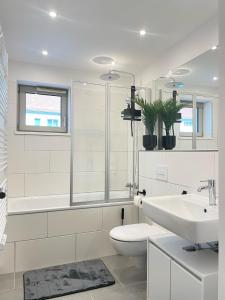a white bathroom with a toilet and a sink at LIGHTPLACE • Design • Boxspring • Balkon • 2 Smart TV •Innenstadt in Braunschweig