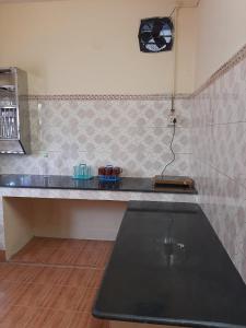 a kitchen with a counter top and a clock on the wall at Sea Edge Homestay in Port Blair