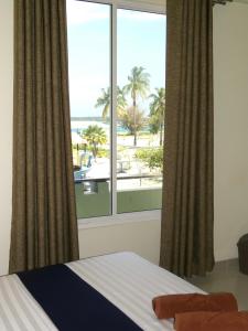 una camera da letto con finestra affacciata sulla spiaggia di Oren a Maamigili