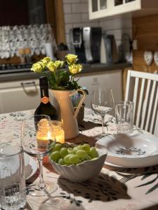 uma mesa com uma taça de uvas e uma garrafa de vinho em Chata Lawendowa em Sasino