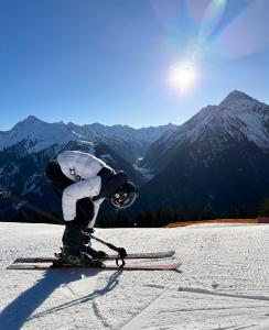 una persona sugli sci nella neve in montagna di Apart Ahorn a Finkenberg