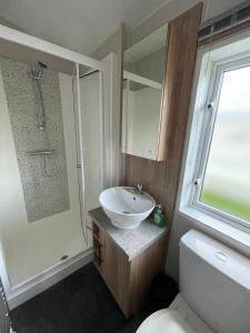 a bathroom with a sink and a shower and a toilet at 2-6 guests Holiday Chalet in Durdle Door in West Lulworth