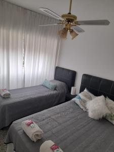 Un dormitorio con dos camas y un ventilador de techo. en HOTEL SOLEADO MH, en Monte Hermoso
