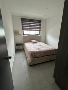 um pequeno quarto com uma cama e uma janela em Apartment in Tijuana em Tijuana