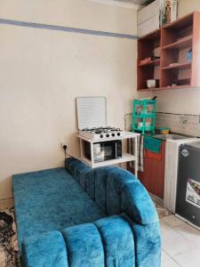 un salon avec un canapé bleu dans une cuisine dans l'établissement Atiram furnished apartments, à Nakuru