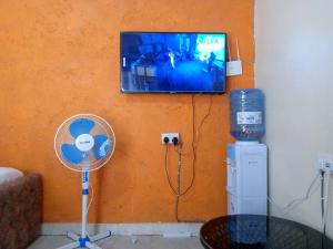 a room with a fan and a television on a wall at Atiram furnished apartments in Nakuru