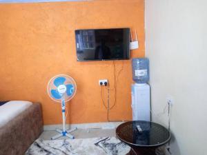 a living room with a fan and a tv on a wall at Atiram furnished apartments in Nakuru