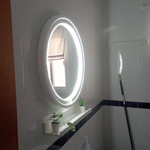 埃爾博斯克的住宿－Ático Los Arcos，一间带圆形镜子和水槽的浴室
