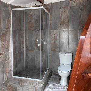 a bathroom with a toilet and a glass shower at Samara Lodge in Vilanculos