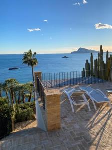 un patio con tavolo, sedie e vista sull'oceano di El jardin Botánico Villa LUZ ad Altea
