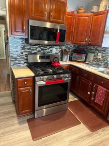 a kitchen with a stove and a microwave at Genevieve’s comfort pad in Jersey City