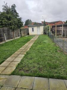 a yard with a fence and a house at Beautiful 5 single bedroom house in Dagenham