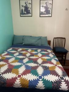 a bed with a colorful quilt on it in a bedroom at Genevieve’s comfort pad in Jersey City
