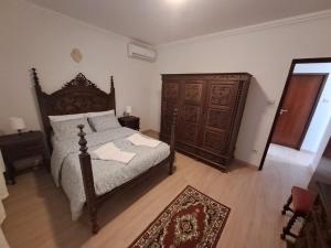 的住宿－Casinha da Glória，一间卧室配有一张大床和一个木制梳妆台