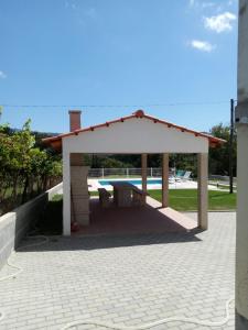 un pabellón con una mesa de picnic en el patio en Casinha da Glória, 