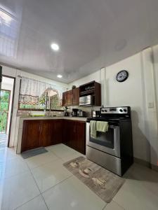 a kitchen with a stainless steel stove and cabinets at Mary's House in Libertad