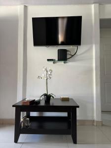 a black table with a tv on a wall at Mary's House in Libertad