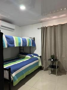 ein Schlafzimmer mit einem Etagenbett in Blau und Grün in der Unterkunft Mary's House in Libertad