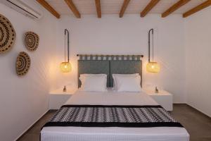 a bedroom with a large bed with two lamps at Raffar luxury houses in Tinos