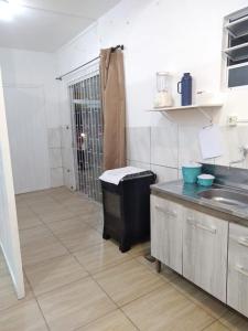 a kitchen with a trash can and a sink at Kitnet Avenida in Imbituba