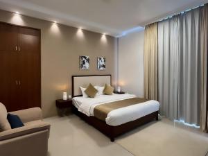 1 dormitorio con 1 cama, 1 sofá y 1 silla en Daar AL Maqam Suites Apartments Salalah en Salalah