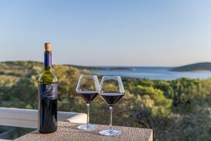 Una botella de vino y dos copas en una mesa. en B&B Paradiso - Pakleni Islands Hvar en Hvar