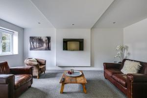 sala de estar con muebles de cuero y TV en Moselle House, en Biggin Hill