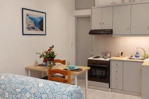 a kitchen with a table and a kitchen with a stove at Seaside cushy studio in Kampos Paros
