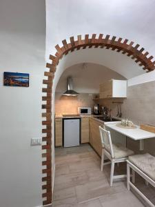 einen Torbogen in einer Küche mit einem Tisch und Stühlen in der Unterkunft Amaré Guest House in Neapel