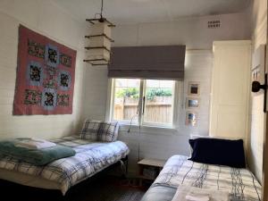1 dormitorio con 2 camas y ventana en Kimberley Blue West Wing Sunny Decks Cosy Fire, en Blackheath