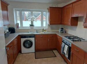 a kitchen with a washing machine and a stove at 2 Bedroom Apartment in Exhall +10 photos