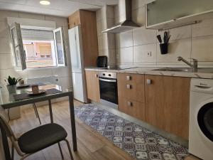 a kitchen with a table and a sink and a stove at PASARELA ALMOZARA HOME in Zaragoza