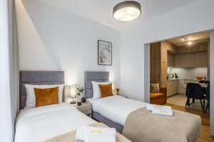 2 camas en una habitación pequeña con cocina en Emihouse Riverside Apartments, en Rzeszów