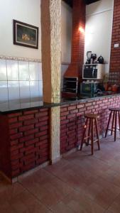 cocina con encimera de ladrillo y 2 taburetes en Chacara muito bonita região de Limeira - Sp en Limeira