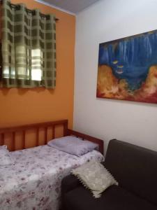um quarto com uma cama, um sofá e um quadro em Chacara muito bonita região de Limeira - Sp em Limeira