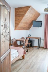 Pokój ze stołem i drewnianymi drzwiami w obiekcie Goralsko Manufaktura w Bukowinie Tatrzańskiej