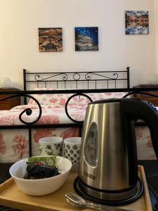 ローマにあるMio House Vaticanのお茶セット、ベッドサイドのテーブルの上のボウルが備わります。