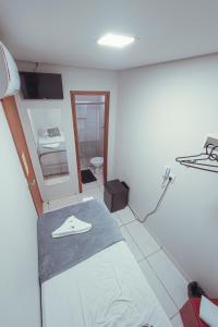 Habitación hospitalaria con cama y espejo en Hotel Apiacas, en Ribeirão Preto