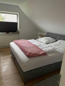 a bed in a bedroom with a window at Ferienwohnung Fehn in Rhauderfehn