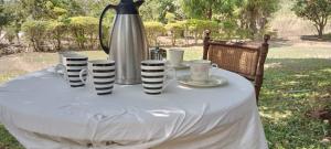 a table with a white table cloth and a tea kettle at Daliko Farm 