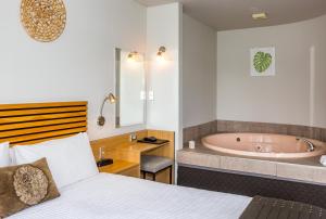 a bedroom with a bed and a bath tub at Clearwater Motor Lodge in Taupo