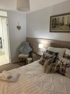 ein Schlafzimmer mit einem großen Bett und einem Stuhl in der Unterkunft SUNNY RHYL BUNGALOW in Rhyl