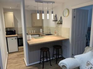 een keuken met 2 barkrukken en een aanrecht bij SUNNY RHYL BUNGALOW in Rhyl