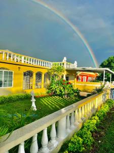 a rainbow in front of a house with a fence at Portmore Havens 1Bedroom EntireGuest House in Portmore