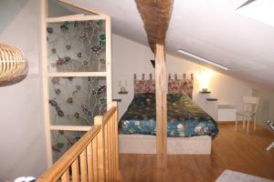a bedroom with a bed in a attic at La p'tite maison in Lussas-et-Nontronneau