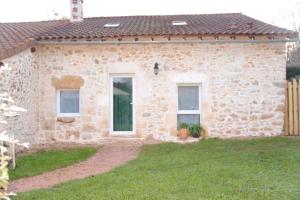 La p'tite maison في Lussas-et-Nontronneau: منزل حجري مع نافذتين وساحة
